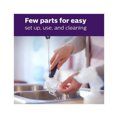 Hand washing a breast pump part under running water, highlighting its easy setup, use, and cleaning features.