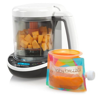 Baby Brezza Food Maker Complete, featuring a clear container with diced fruit, a digital display, and a colorful food pouch.