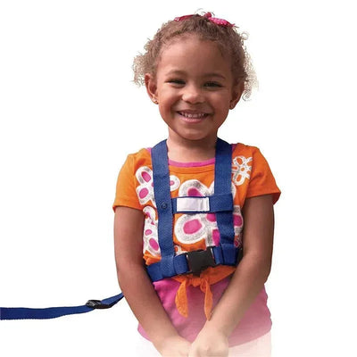 Child smiling while wearing a black Baby Buddy Deluxe Security Harness, designed for safety and mobility.