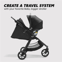 Baby Jogger City Go 2 Infant Car Seat in Frosted Ivory attached to a stroller, showcasing a travel system with a black canopy.