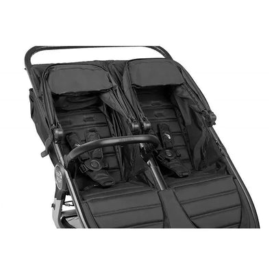 Black double stroller with two seats and a safety bar, designed for infants and toddlers.