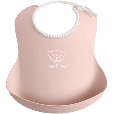 Powder pink BabyBjörn baby bib with a white bear logo and a flexible pocket for catching food spills.