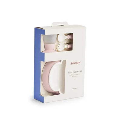 BabyBjorn baby feeding set in powder pink, includes a plate, bowl, cup, and utensils, packaged in a clear box.