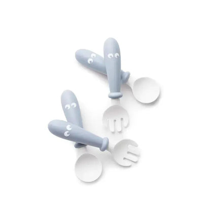 BabyBjorn powder blue baby spoon and fork set, featuring soft handles with cute eyes, designed for toddlers.