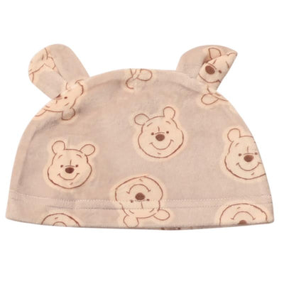 Winnie the Pooh-themed baby hat with cute bear ears and smiling Pooh faces on a soft beige fabric.