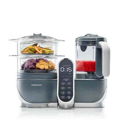 Babymoov Duo Meal Station 5-in-1 food maker in grey with steam cooker, blending jar, and control panel showing timer.