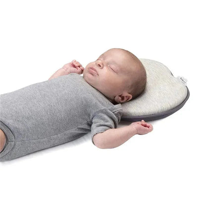 Baby resting on a soft, heart-shaped Babymoov Lovenest pillow in smokey color, promoting healthy head positioning while sleeping.