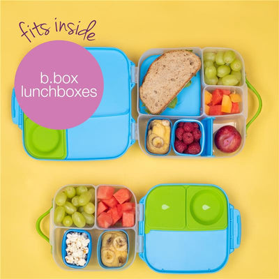 Silicone snack cups in a b.box lunchbox, containing a sandwich, fruits, and snacks on a yellow background.