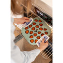 Béaba Silicone Mini Multiportion Tray in sage green, filled with baked goods, being removed from the oven.
