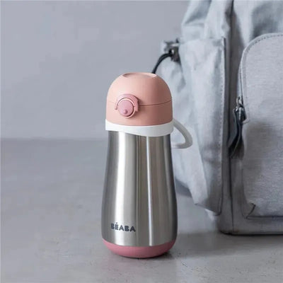 Stainless steel kids water bottle in rose color with a pink lid and white accents beside a light gray backpack.