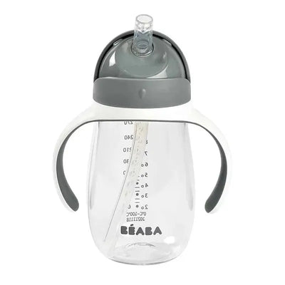 Beaba Straw Sippy Cup in charcoal color with transparent body, measurement markings, and ergonomic handles.