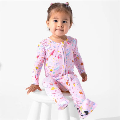 Toddler wearing a pink Harry Potter-themed bamboo convertible footie with colorful magical motifs, sitting on a stool.