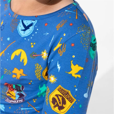 Blue pajamas featuring Harry Potter-themed graphics, including house crests and magical symbols, worn by a child.
