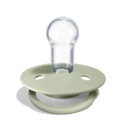Silicone pacifier in sage green color with a clear nipple, designed for infants, featuring ventilation holes.