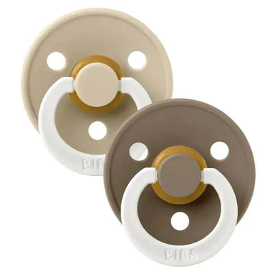 Two BIBS rubber baby pacifiers in vanilla and dark oak colors, designed for ages 6 to 18 months, with round shields and grip rings.