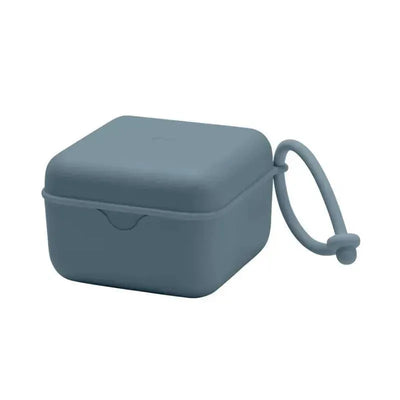 Square petrol-colored pacifier box with a closure and a loop for easy carrying.