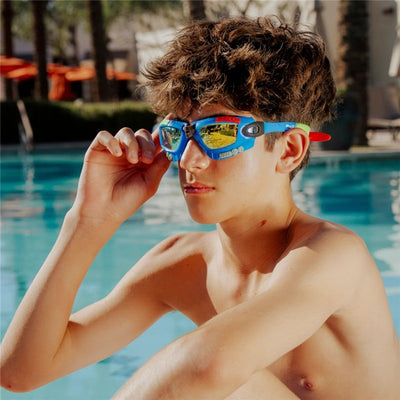 Cobalt blue swim goggles on a boy adjusting them by the pool, showcasing colorful lenses and sporty design.