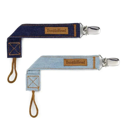 Two denim pacifiers in luxury styles: one dark blue and one light blue, both with BooginHead labels and metal clips.