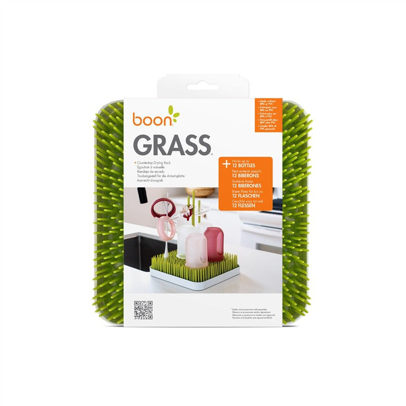 Boon Grass countertop drying rack in green, designed for drying baby bottles and pacifiers, with product packaging visible.