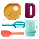Toddler food prep set featuring a yellow mixing bowl lid, purple grip, aqua measuring cup, turquoise whisk, and orange spatula.