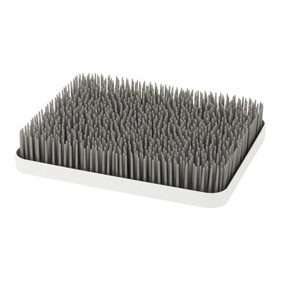 Boon LAWN countertop drying rack in gray and white, featuring numerous upright spikes for drying dishes and utensils.