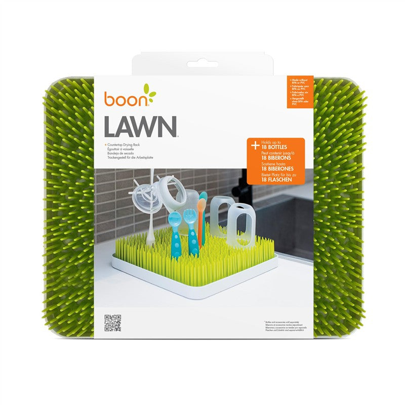 Countertop drying rack for bottles and utensils, featuring a green grass-like design with a white base.