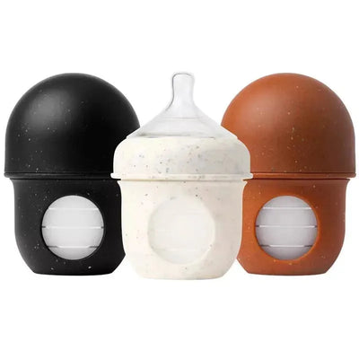 Boon NURSH Silicone Pouch Baby Bottles, 4 fl oz, three-pack in black, white speckled, and orange colors.