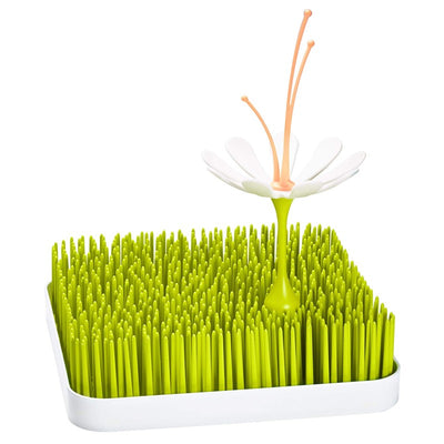 Boon STEM & TWIG drying rack accessories featuring a green grass-like base and a flower with orange stems for drying bottles.