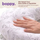 Boppy Nursing Pillow in Blush Butterflies with a hand resting on it, showcasing its soft, floral-patterned cover.