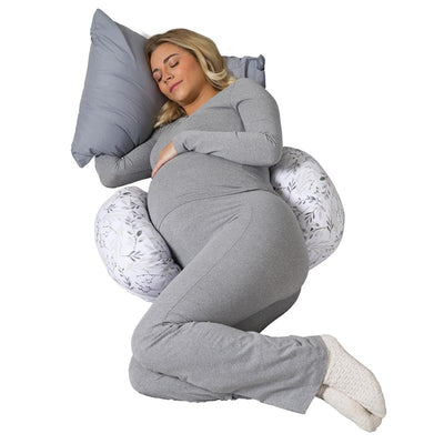 Pregnant woman in gray sleepwear resting with a Boppy Side Sleeper pillow featuring a gray and white falling leaves design.