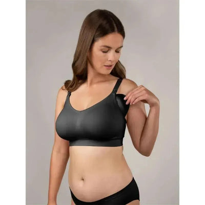 Bravado Body Silk seamless nursing bra in black, worn by a woman adjusting the strap, showcasing its functionality.