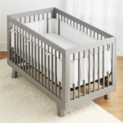 Classic Breathable Mesh Crib Liner in white, fitted inside a modern gray crib with slatted design.