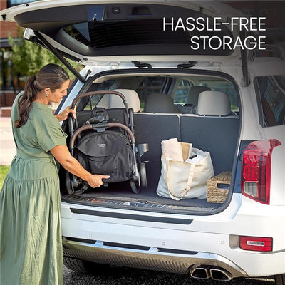 A woman placing a Britax Juniper Compact On-The-Go Stroller in the trunk of an SUV, demonstrating hassle-free storage.