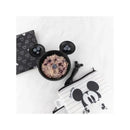 Black silicone bowl with mouse ears holding oatmeal and blueberries, accompanied by a patterned cloth and a zippered pouch.