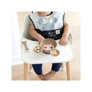 Baby wearing a Mickey Mouse bib sits in a high chair with a silicone feeding set, including bowls of food and a spoon.