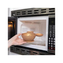 A hand holding a gold Bumkins Disney silicone feeding bowl set inside a microwave.