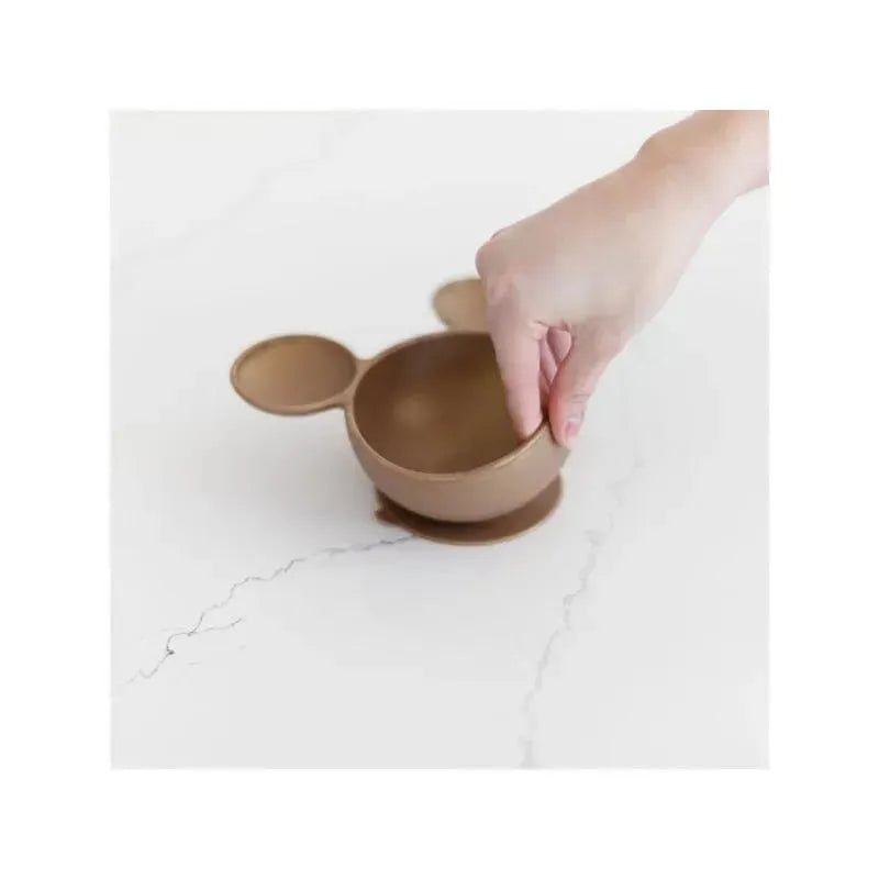 Silicone bowl shaped like a Disney character, with a hand reaching to lift it from a marble surface.