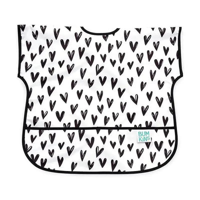 Bumkins Junior Bib featuring a white background with scattered black heart designs and a front pocket.