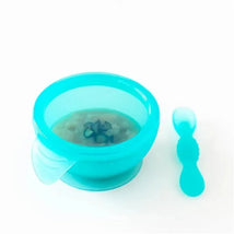 Silicone feeding set in blue with a suction bowl and matching spoon, designed for babies and toddlers.