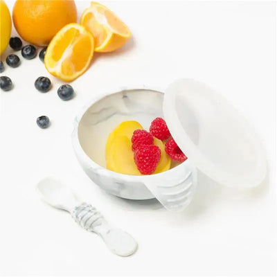Bumkins Silicone First Feeding Set in marble pattern featuring a bowl with a lid, spoon, and colorful fruit inside.