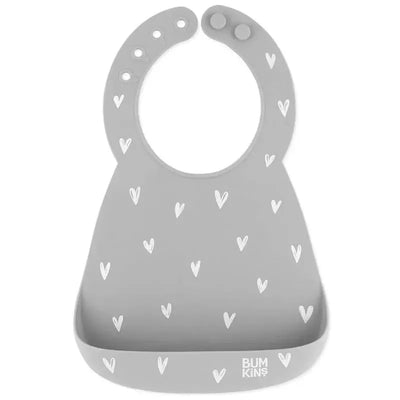 Silicone bib in gray with a heart pattern, featuring a catch-all pocket and the Bumkins logo.