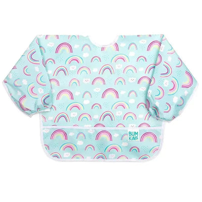 Sleeved bib by Bumkins featuring a pastel blue background with colorful rainbows and clouds.