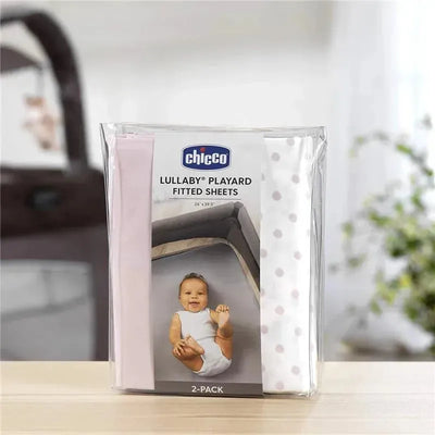 Chicco 2 Pack Lullaby Playard Sheets in pink and white with polka dots, featuring a baby on the packaging.