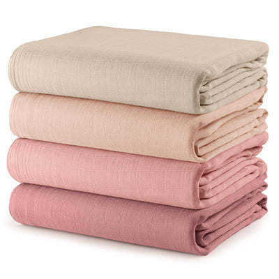 Four muslin swaddle blankets in cream, blush, bold blush, and mauve, neatly stacked, showcasing their soft texture.