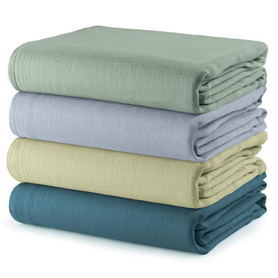 Comfy Cubs 4-pack muslin swaddle blankets in sage, pacific blue, fern, and neptune colors, neatly stacked.