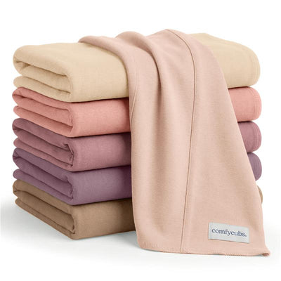 Multicolor set of six Comfy Cubs baby burp cloths stacked, featuring soft fabric in pastel shades suitable for girls.