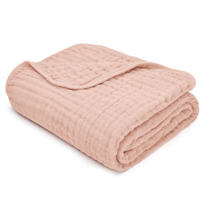 Muslin baby blanket in blush color, soft texture with a quilted pattern, neatly folded.