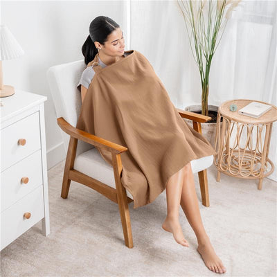 Muslin nursing cover in cedar color draped over a seated woman, providing privacy while breastfeeding.