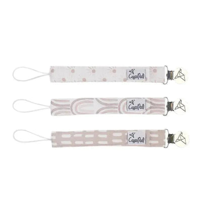 Three Copper Pearl binky clips in different patterns: a dot print, a rainbow design, and a solid line pattern.