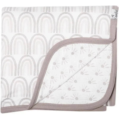 Soft quilt blanket featuring a light grey rainbow pattern on one side and a sunburst design on the reverse, edged in taupe.